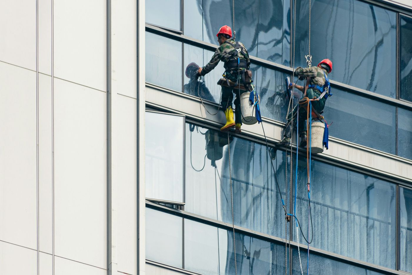 Obra com grua e trabalhador de capacete, ou limpeza profissional de um espaço